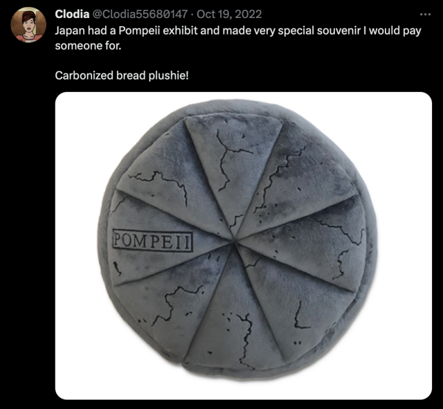 A tweet from Clodia @Clodia55680147, reading: "Japan had a Pompeii exhibit and made very special souvenir I would pay someone for. Carbonized bread plushie!" followed by a picture of a carbonized bread plushie.
